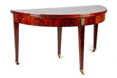 null Mahogany veneered half-moon table resting on four legs with gilded bronzes....
