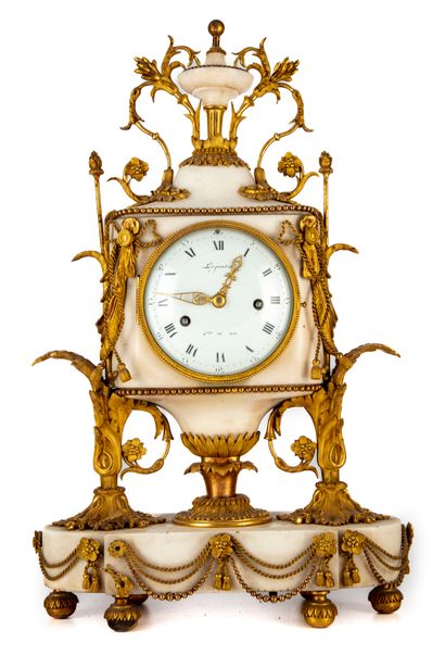 null Beautiful white marble clock in the form of a vase on a pedestal. Rich ornamentation...