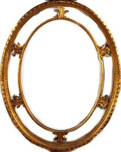 Miroir ovale en bois doré à parecloses ciselées...