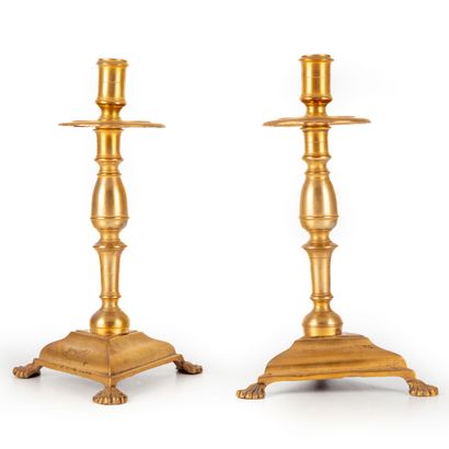 null Paire de bougeoirs en bronze à fût balustre et base triangulaire sur pieds griffes....