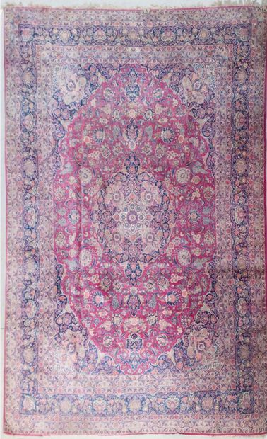 null Important tapis persan à motifs de rinceaux et fleurs sur champ rouge et bleu

440...