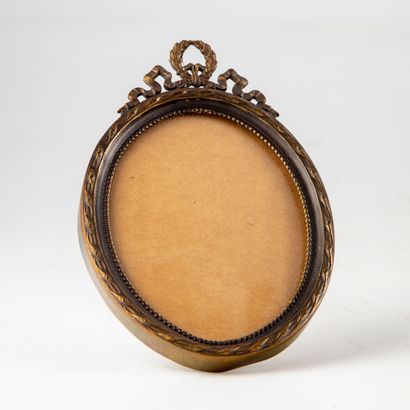 null Small gilt metal oval photo frame in the Louis XVI style with a crossed ribbon...