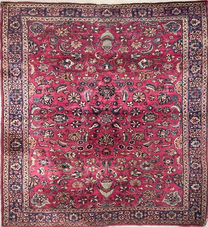 null Tapis persan à motif floral sur champ framboise. Triple bordure 
262 x 180 cm...