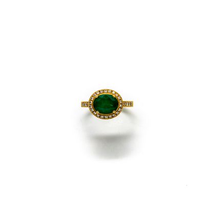 Yellow gold ring set with an emerald surrounded...