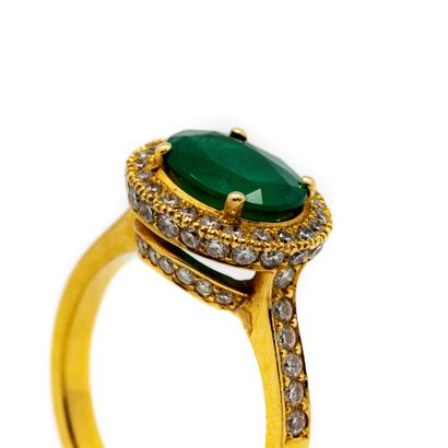 null Yellow gold ring set with an emerald surrounded by a pavement of small diamonds.
TDD...