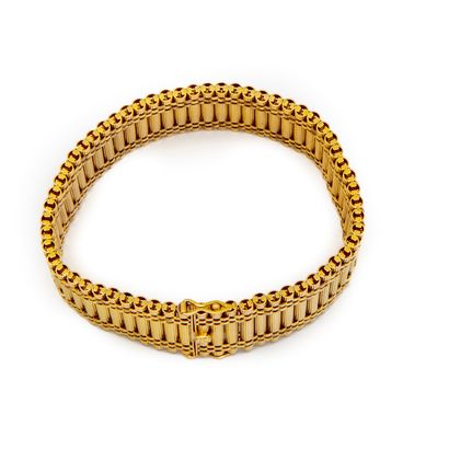 null Yellow gold cuff bracelet with flexible links forming a frieze of fluted baguettes...