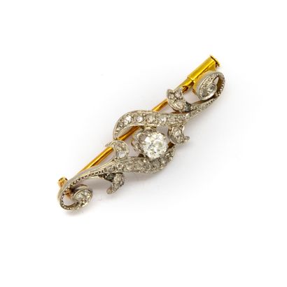 null Gold brooch with an old cut diamond and a pavement of diamonds in scroll.
Gross...
