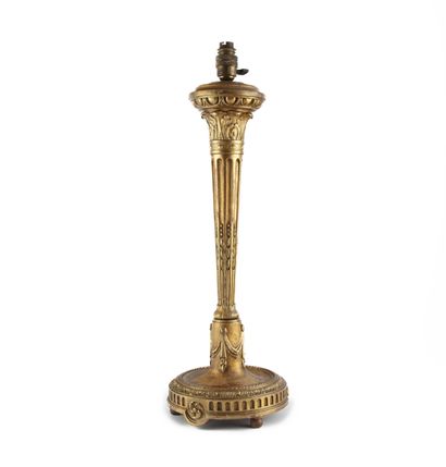 null Lampe en bois sculpté et doré de style Louis XVI.
H. : 60 cm.