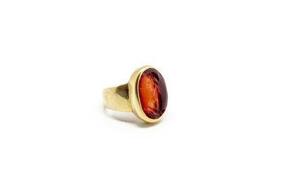 null Yellow gold signet ring set with a glyptic-engraved hard stone featuring a mythological...