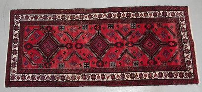 null Woolen gallery carpet decorated with three diamond medallions on red field....