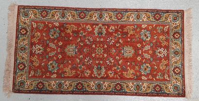 null Small mechanical carpet of Persian style with floral design on red background....
