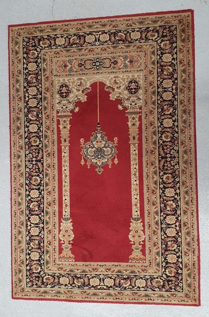 null Mechanical prayer rug decorated with mihrab with columns on a red background....