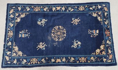 null Tapis en laine à décor sur champ bleu d'ustensiles. Bordure fleurie. Style chinois
210...