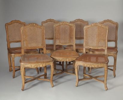 null Suite de sept chaises cannées en hêtre naturel à décor de rinceaux de feuillages...
