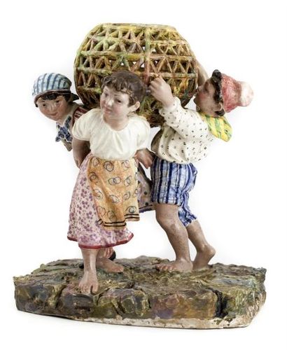 Groupe en faïence émaillée représentant 3 enfants en tenue bavaroise tenant une sphère...