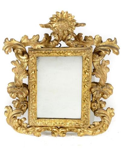 Miroir en bois doré à décor ajouré de feuillages. Miroir en bois doré à décor ajouré...