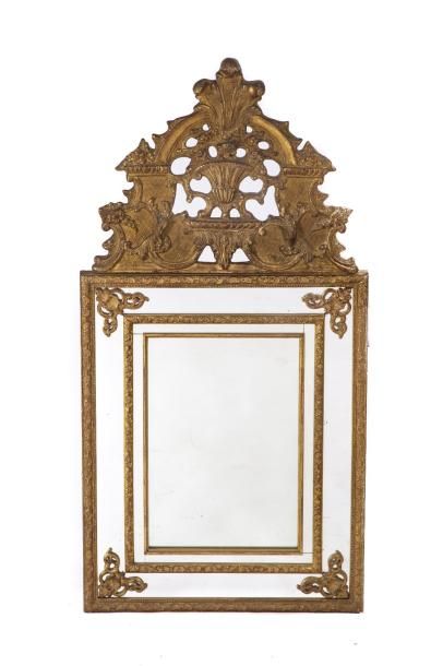 Miroir en bois doré à décor de vase, feuillages et palmette. Miroir en bois doré...
