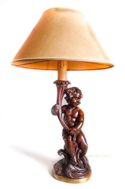 LAMPE EN BOIS NATUREL Lampe en bois naturel représentant un putto tenant une torche...