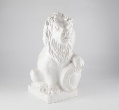 LION EN FAÏENCE ÉMAILLÉE Lion en faïence émaillée blanc, la patte avant reposant...
