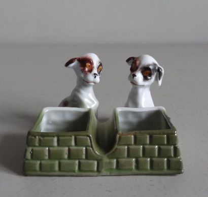 null Saleron double en porcelaine polychrome en forme de chiens devant leurs mangeoirs.
L....