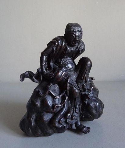 null CHINE
Statuette en bronze patiné représentant un homme assis sur un rocher tenant...