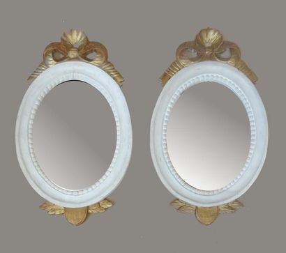 null Paire de miroirs de forme ovale en bois laqué blanc à feuillure ciselé d'une...