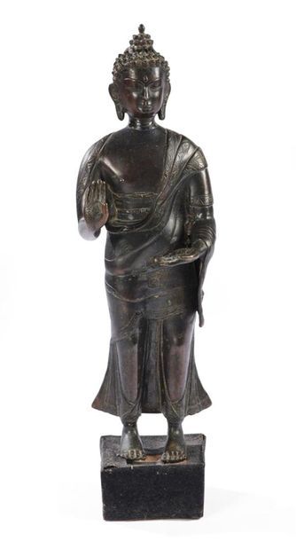 null TIBET - Vers 1900
Statuette de bouddha debout en bronze à patine brune la main...