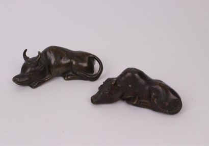 null JAPON, XIXe siècle 
Deux bovins couchés en bronze. 
Long. 9,5 cm et 10,5 cm...