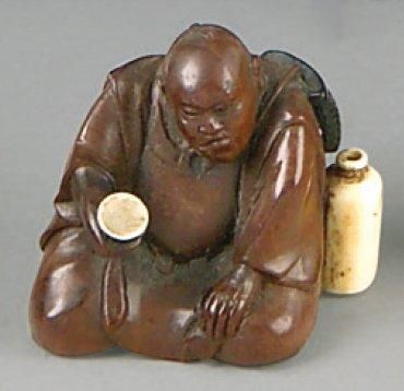 null Netsuke en bois et ivoire, samouraï assis tenant une coupe à saké, une jarre...