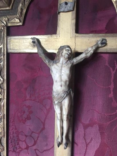 null Crucifix en ivoire 
H.: 40 cm 
Dim. du cadre en bois doré: 55x 37 cm
Fin du...