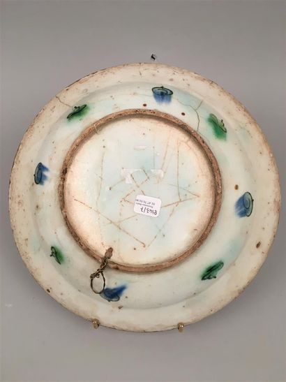 null Iznik Plat rond en céramique siliceuse à glaçure plombifère à décor polychrome...