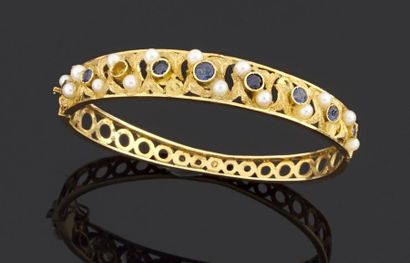 null Bracelet rigide et ouvrant en or jaune ajouré 750 millièmes, orné de saphirs...