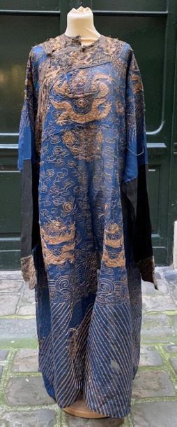 null CHINE 
Robe de mandarin en gaz à fond bleu à décor brodé au fil d'or de dragons.
Début...