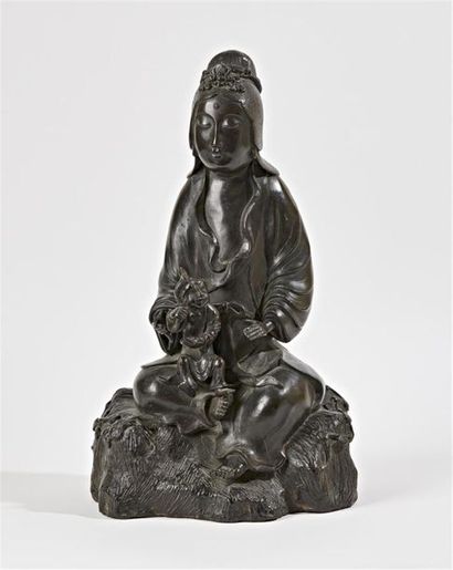 null CHINE - Vers 1900
Statuette de guanyin assise en bronze à patine brune tenant...