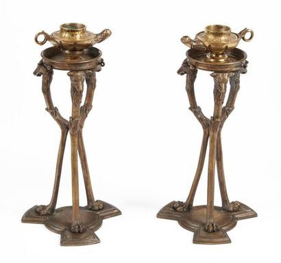 null Pair of bronze selettes decorated with wolf heads, bearing flamed pots. Signed...