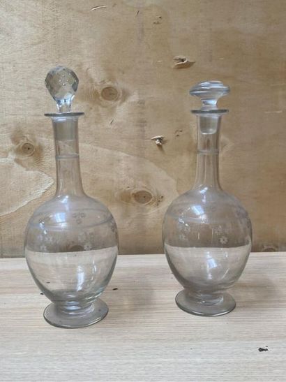 null DEUX CARAFES en cristal gravé à décor de fleurettes. 
Deux bouchons rapport...