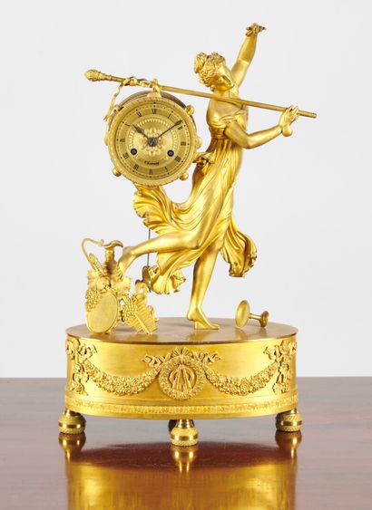 null Pendule en bronze doré représentant une bacchante, sur une base ovale à décor...