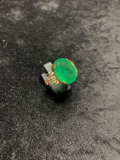 null Yellow gold ring 750 thousandths decorated in the center of an emerald of oval...