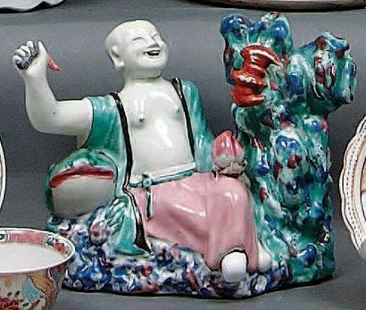 CHINE Figurine représentant un personnage assis tenant une mangue près d'un rocher...