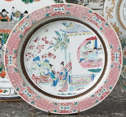 CHINE Plat rond creux décoré en émaux de la famille rose de deux femmes devisant...