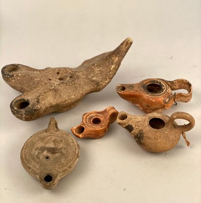 null SET OF FIVE OIL LAMPS in terracotta, one sculpted with antilopines.

Length...