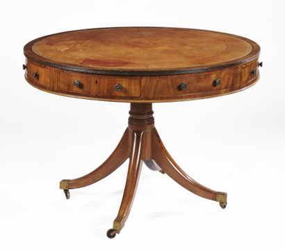 null A round veneered GUERIDON with a top covered with gilt leather, opening to four...