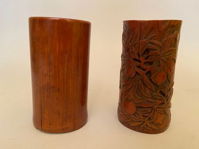 null CHINE 

Deux pots à pinceaux en bambou, l'un sculpté de pêches, l'autre incisé...