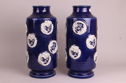 null CHINE

Paire de vases rouleaux en porcelaine à fond bleu à décor de médaillons...