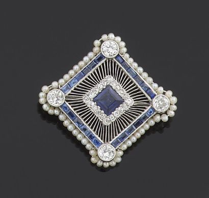 null A diamond-shaped metal brooch set with a sapphire in the center surrounded by...