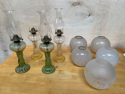 null ENSEMBLE comprenant quatre lampes à pétrole en verre moulé teinté vert ou doré...