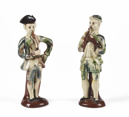 null STAFFORDSHIRE

Two glazed earthenware statuettes representing a flute player...