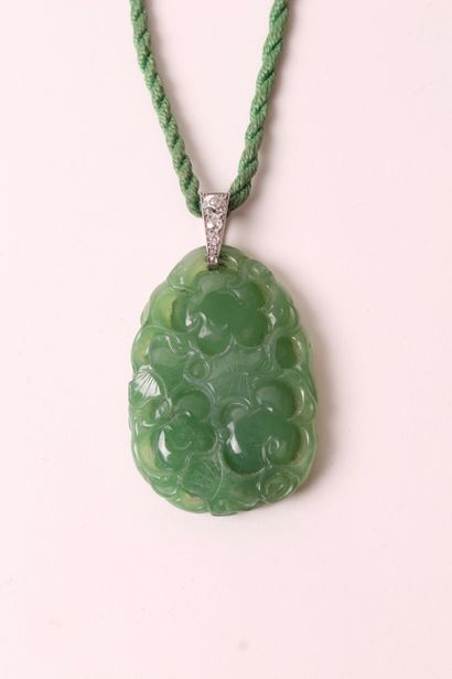 null Collier cordonnet en tissu torsadé retenant en pendentif un motif en jade gravé...