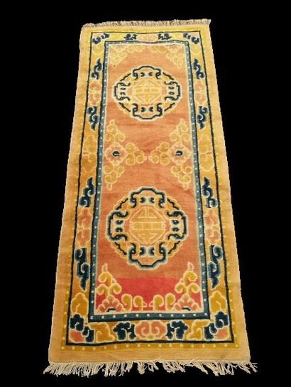 null CHINE 

Tapis en laine à décor de deux médaillons sur fond orangé. 

176 x 74...