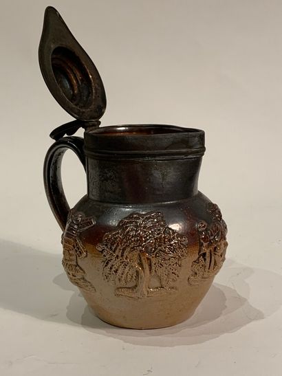 null Enamelled stoneware pitcher decorated with vine leaves and mills and drinkers....